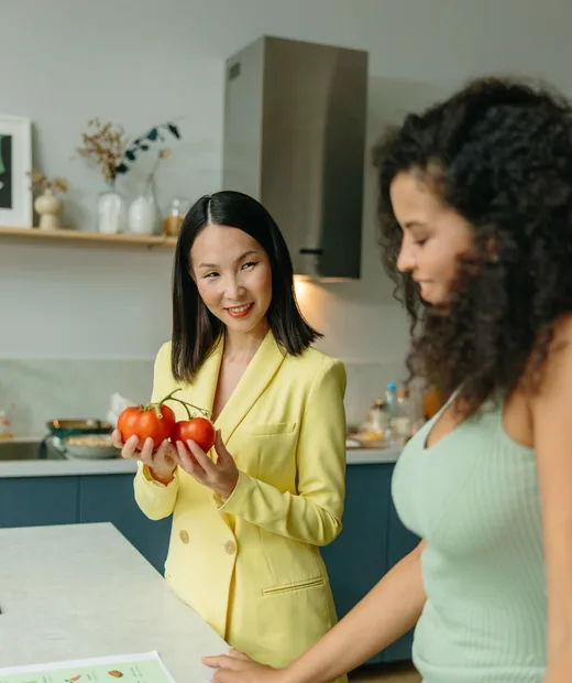 Dos mujeres platicando en una cocina luminosa